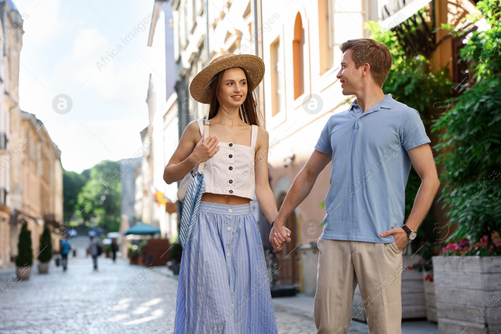 Lovely couple walking together on city street, space for text Photo of Lovely couple walking together on city street, space for text