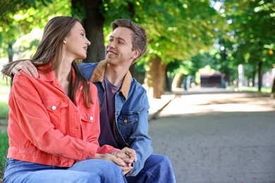 Photo of Lovely couple spending time together in park, space for text