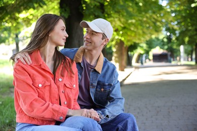 Photo of Lovely couple spending time together in park, space for text