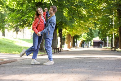 Photo of Lovely couple spending time together in park, space for text