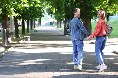 Photo of Lovely couple walking together in park, space for text