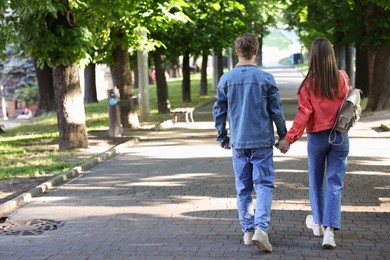 Photo of Lovely couple walking together in park, back view. Space for text