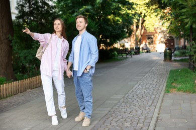 Photo of Lovely couple walking together on city street, space for text