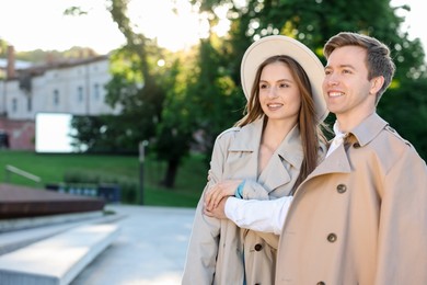 Photo of Lovely couple walking together on city street, space for text