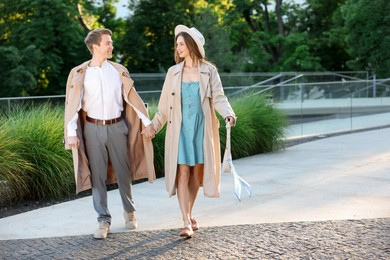 Photo of Lovely couple walking together on city street, space for text