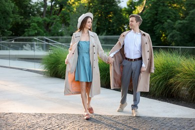 Photo of Lovely couple walking together on city street, space for text