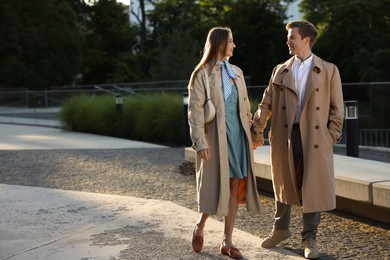 Photo of Lovely couple walking together on city street, space for text