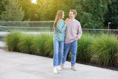 Photo of Lovely couple walking together on city street, space for text
