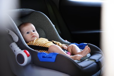 Photo of Cute little baby fastened in car seat