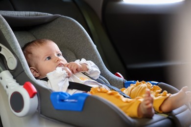 Photo of Cute little baby fastened in car seat