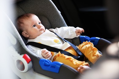 Photo of Cute little baby fastened in car seat