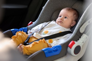 Photo of Cute little baby fastened in car seat