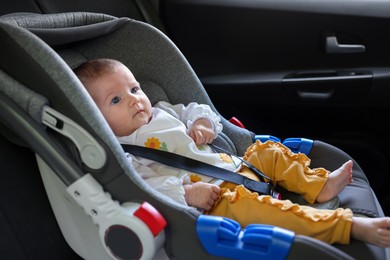 Photo of Cute little baby fastened in car seat