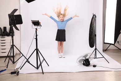 Photo of Little girl on white background in photo studio with professional equipment