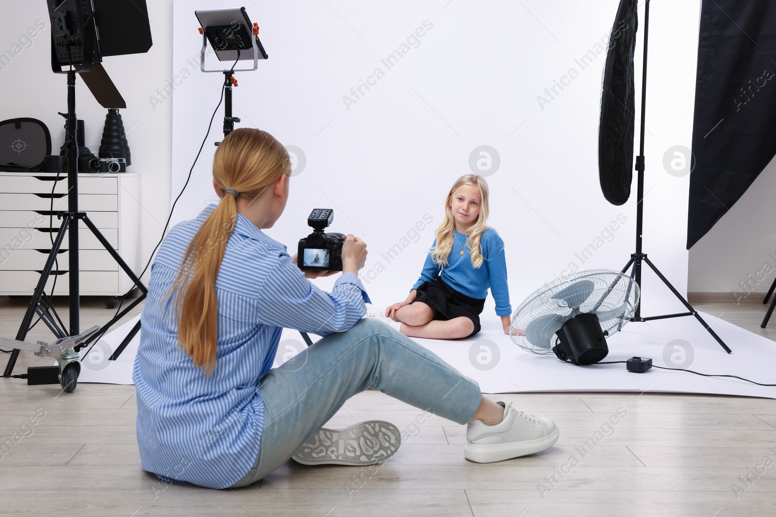 Photo of Photographer working with model in professional photo studio