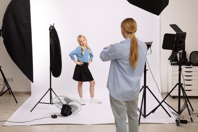 Photo of Photographer working with model in professional photo studio
