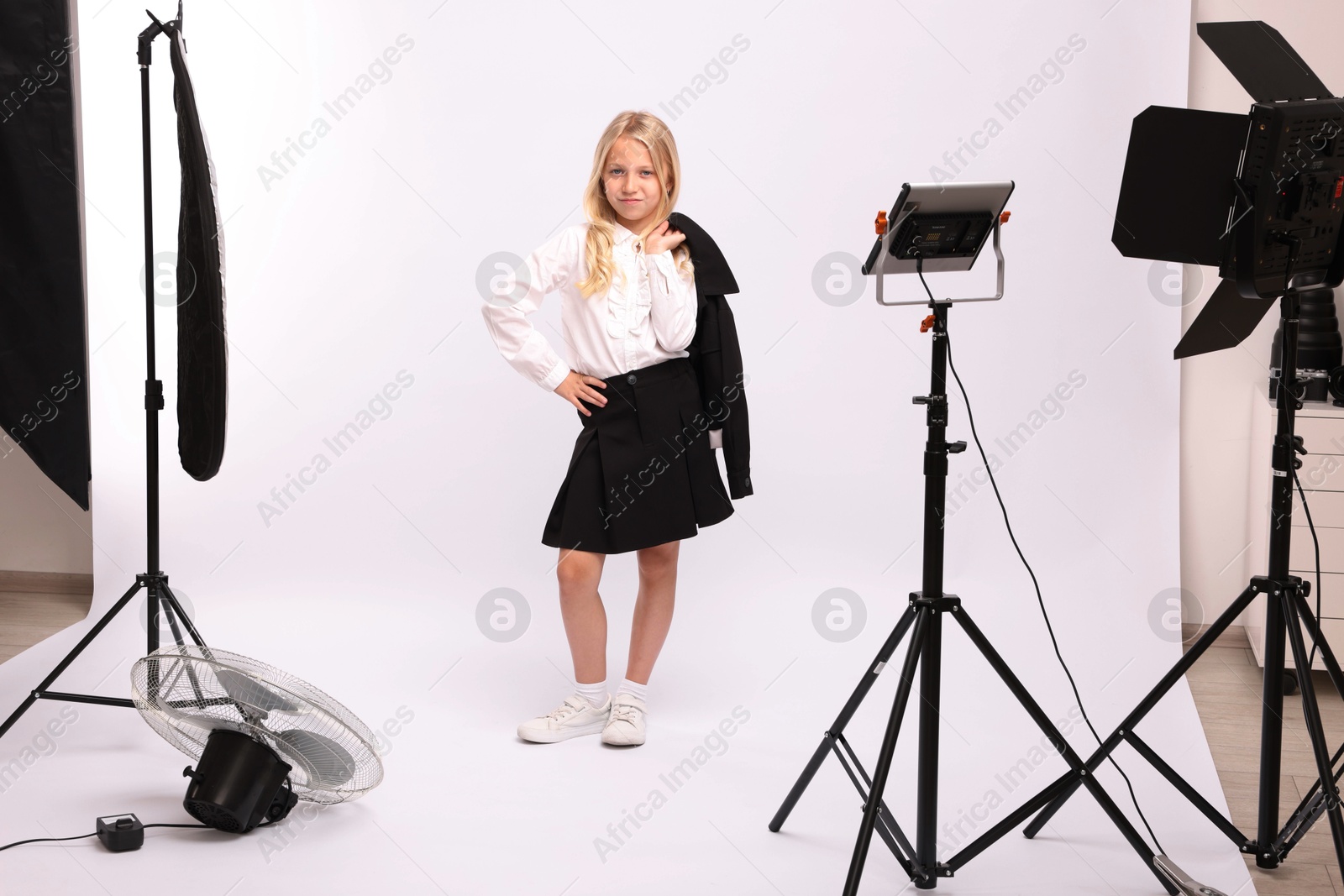 Little girl on white background in photo studio with professional equipment Photo of Little girl on white background in photo studio with professional equipment
