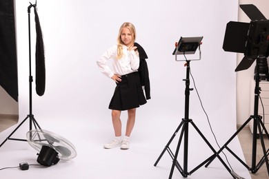 Photo of Little girl on white background in photo studio with professional equipment