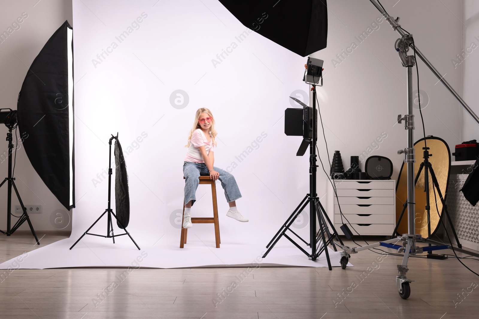 Photo of Little girl on white background in photo studio with professional equipment