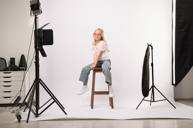 Photo of Little girl on white background in photo studio with professional equipment
