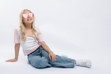 Photo of Little girl on white background in photo studio. Space for text