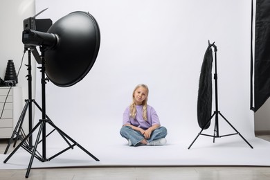 Photo of Little girl on white background in photo studio with professional equipment