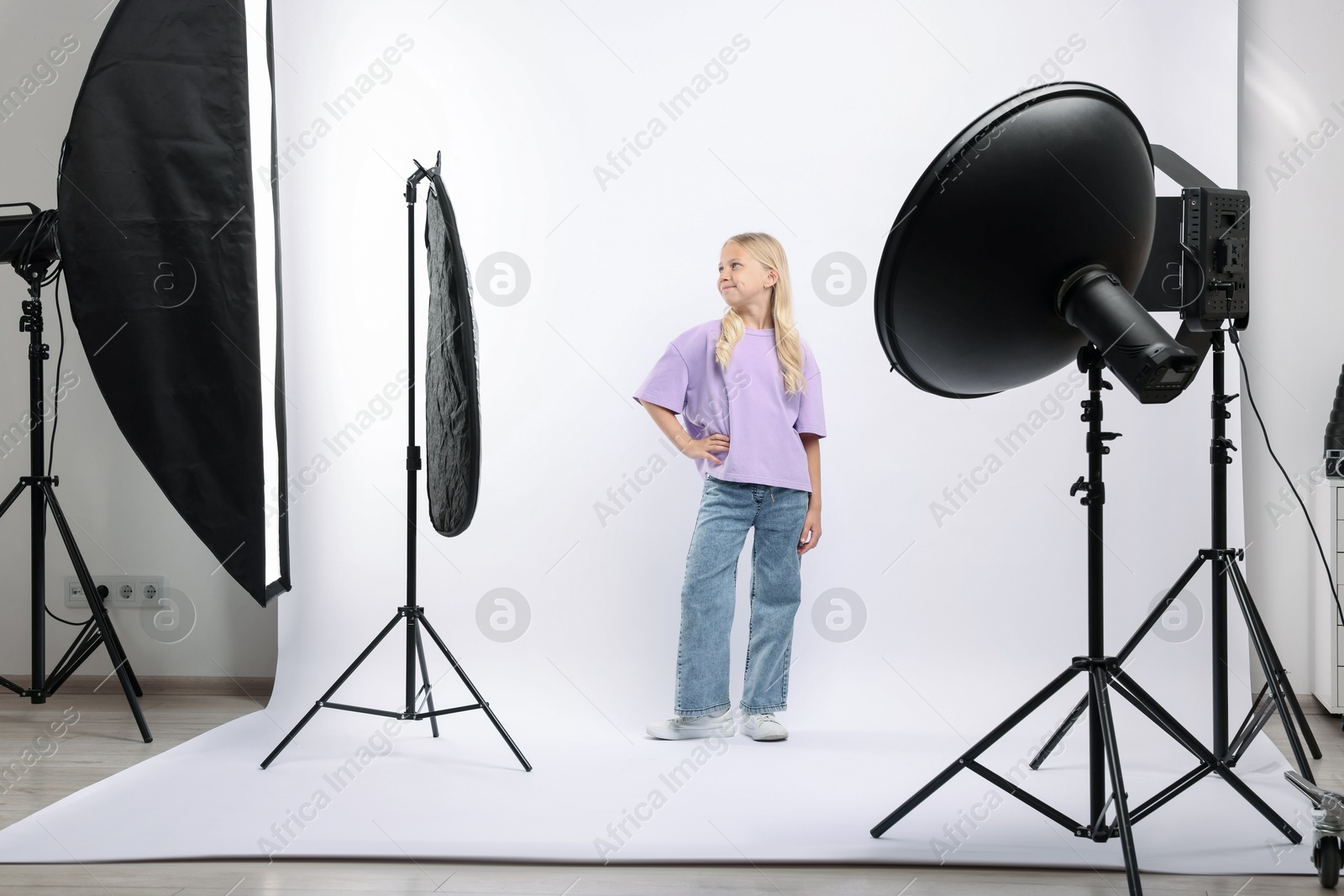Little girl on white background in photo studio with professional equipment Photo of Little girl on white background in photo studio with professional equipment