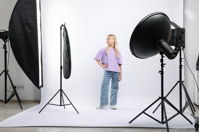 Photo of Little girl on white background in photo studio with professional equipment
