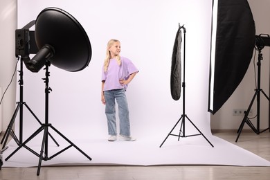 Photo of Little girl on white background in photo studio with professional equipment