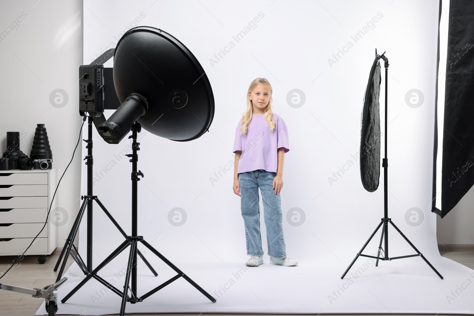 Photo of Little girl on white background in photo studio with professional equipment