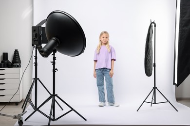 Photo of Little girl on white background in photo studio with professional equipment