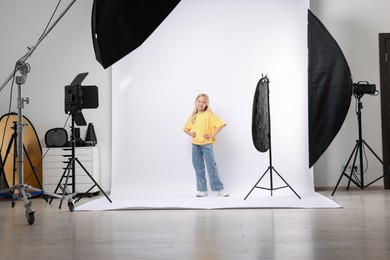 Photo of Little girl on white background in photo studio with professional equipment
