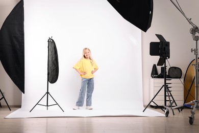 Photo of Little girl on white background in photo studio with professional equipment