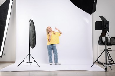 Photo of Little girl on white background in photo studio with professional equipment