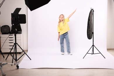 Photo of Little girl on white background in photo studio with professional equipment