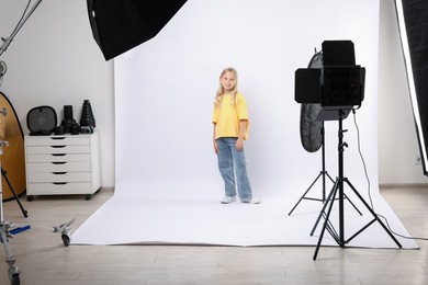 Photo of Little girl on white background in photo studio with professional equipment