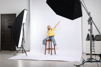 Photo of Little girl on white background in photo studio with professional equipment