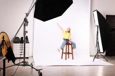 Photo of Little girl on white background in photo studio with professional equipment