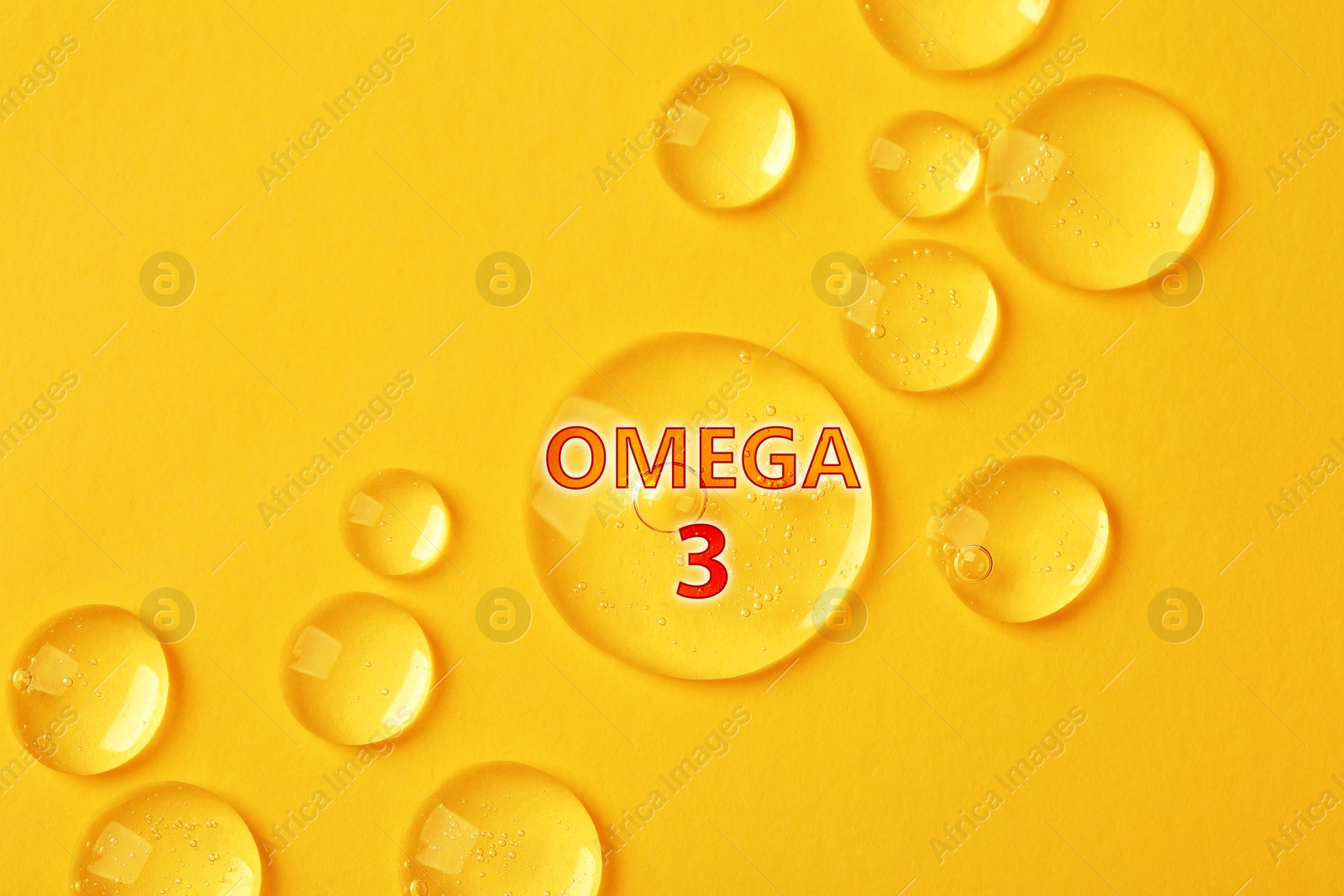 Drops of Omega-3 on yellow background, top view Image of Drops of Omega-3 on yellow background, top view