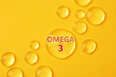 Image of Drops of Omega-3 on yellow background, top view