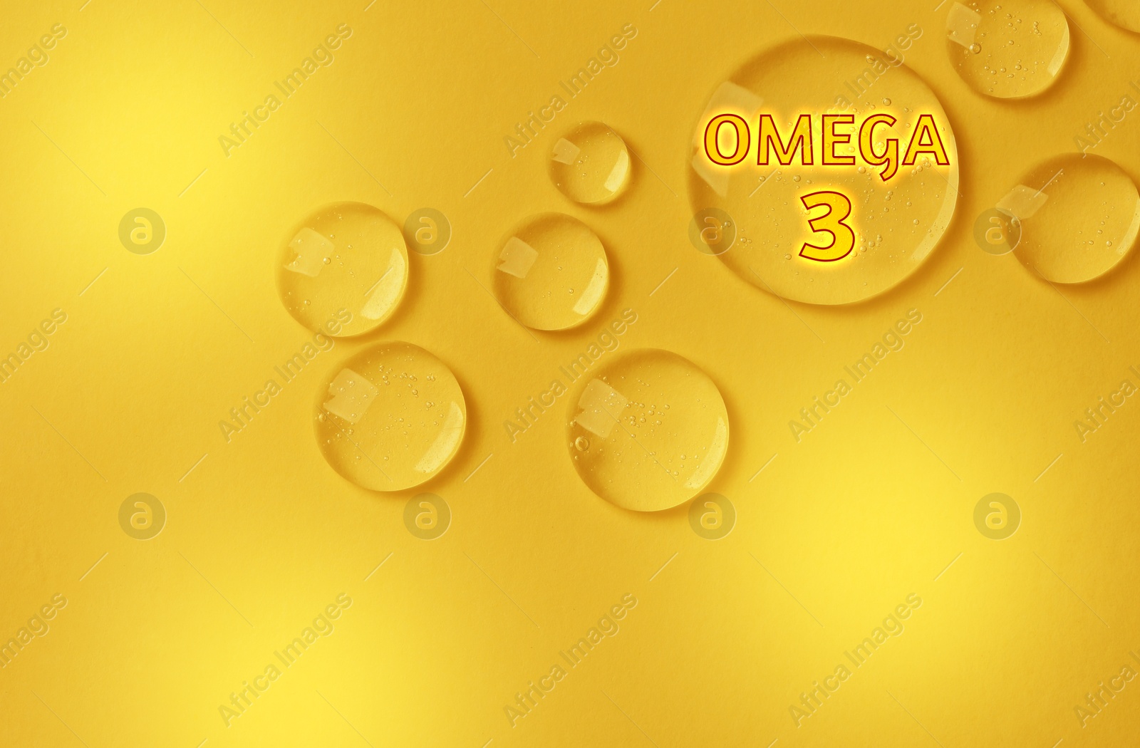 Drops of Omega-3 on yellow gradient background, top view Image of Drops of Omega-3 on yellow gradient background, top view