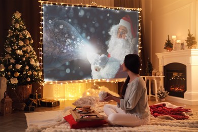 Image of Woman watching Christmas movie using video projector at home