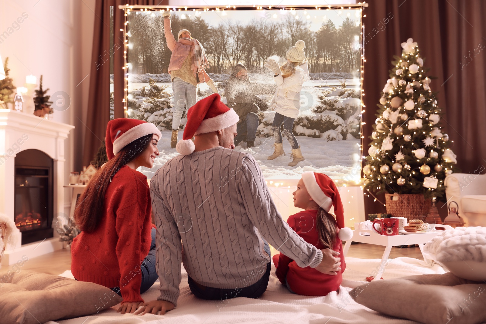 Family watching Christmas movie using video projector at home Image of Family watching Christmas movie using video projector at home