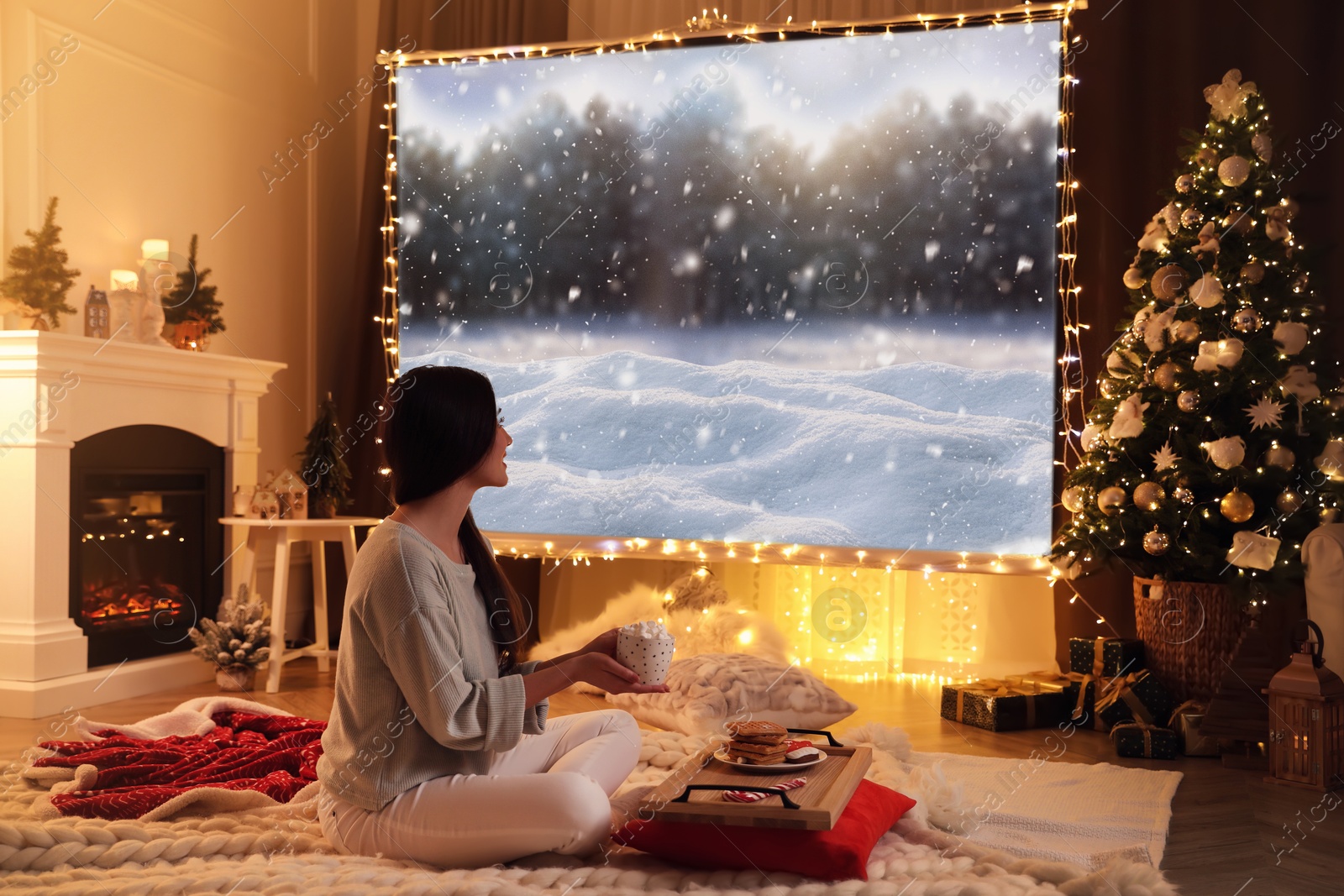 Image of Woman watching Christmas movie using video projector at home