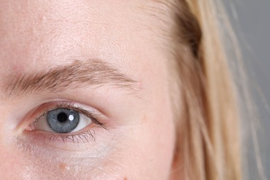 Photo of Woman with beautiful eyes on grey background, closeup