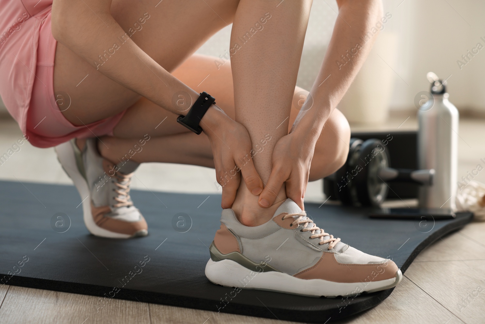 Sports injury. Young woman suffering from leg pain in fitness studio, closeup Photo of Sports injury. Young woman suffering from leg pain in fitness studio, closeup