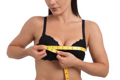 Photo of Woman in beautiful bra measuring breast circumference on white background, closeup