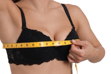 Photo of Woman in beautiful bra measuring breast circumference on white background, closeup