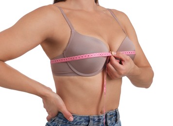 Photo of Woman in beautiful bra measuring breast circumference on white background, closeup