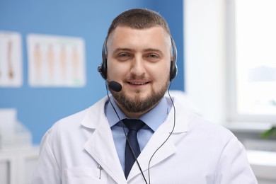 Photo of Doctor with headset in clinic. Online medical consultation